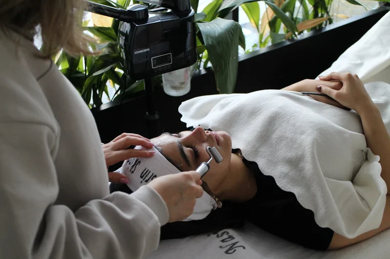 A woman laying on a bed while using a cell phone